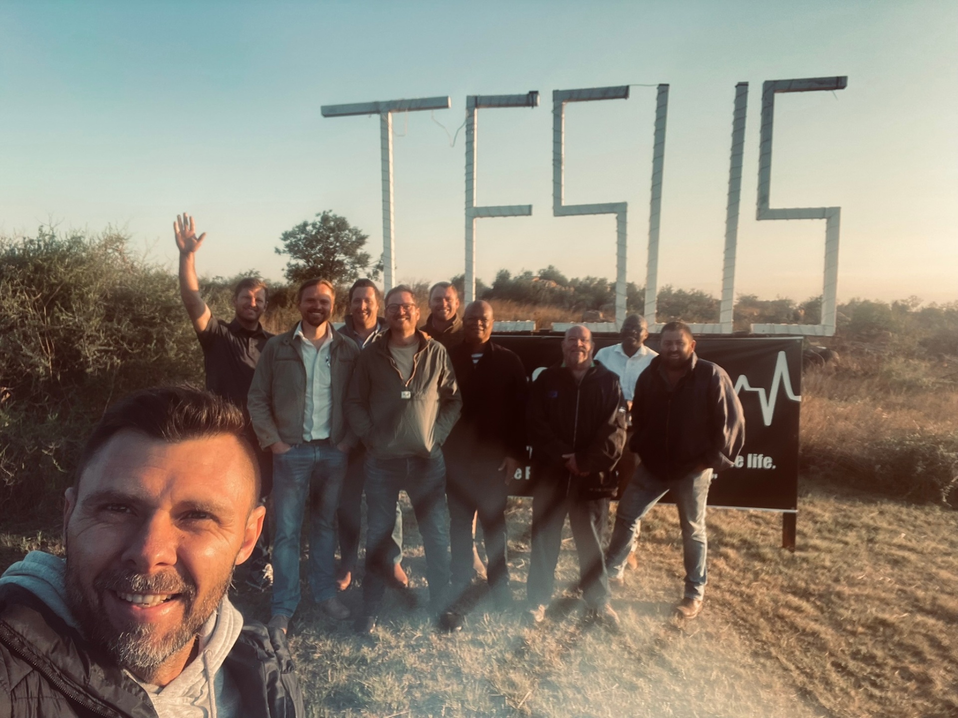 Men's leadership team selfie at sunrise by the JESUS sign