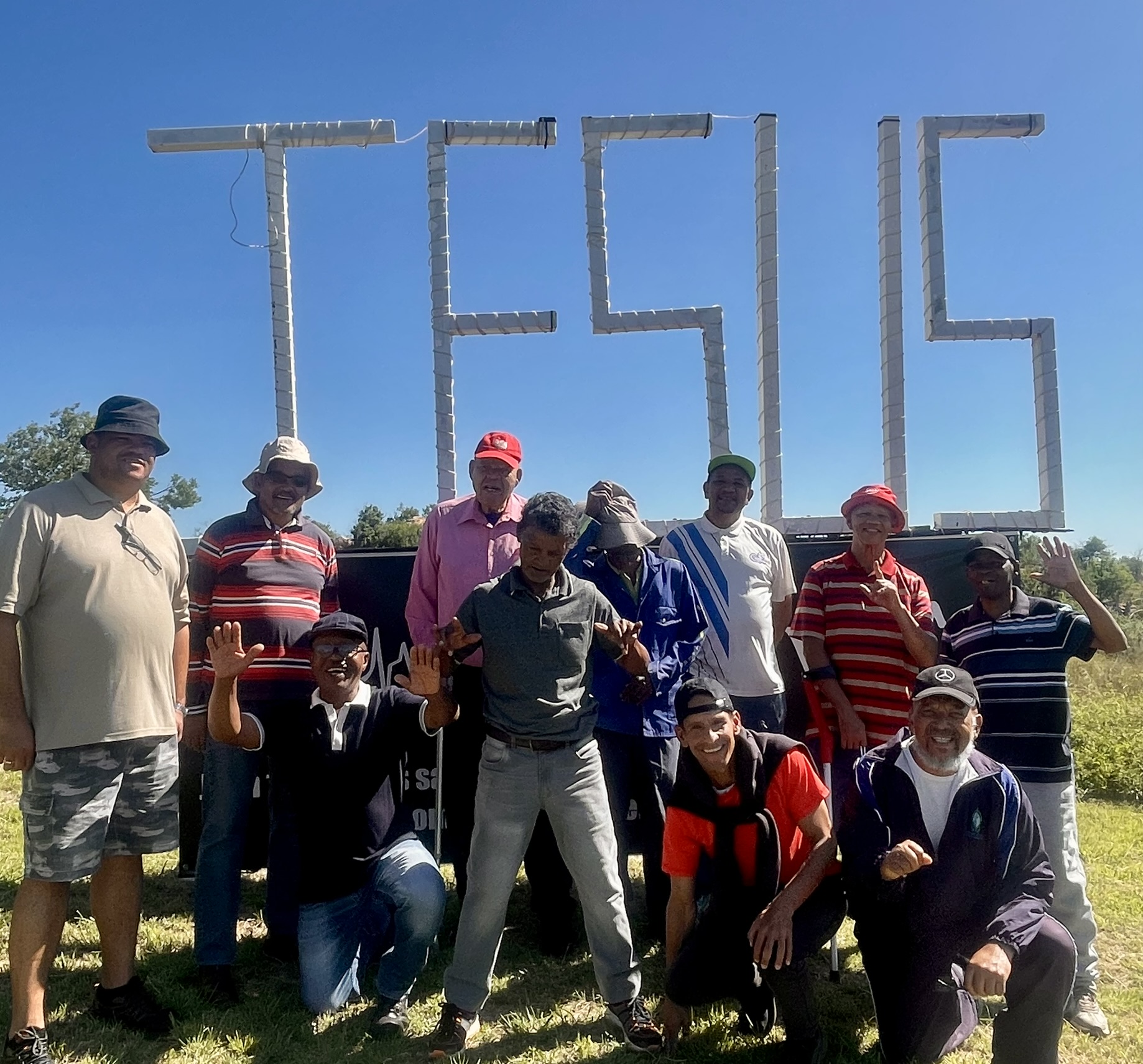 Joyful men's group waving at the JESUS sign