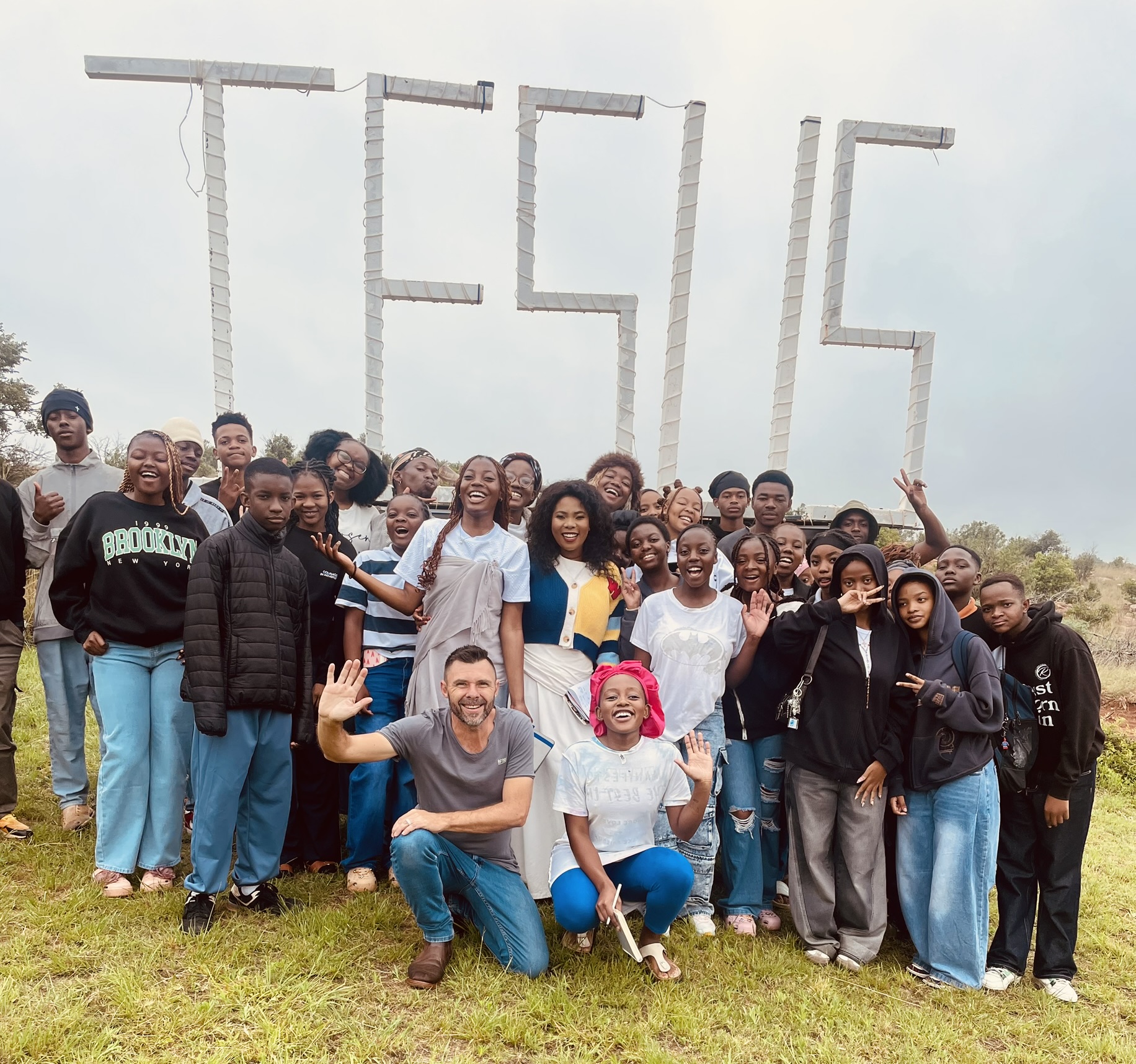 Large youth group gathered beneath the JESUS sign