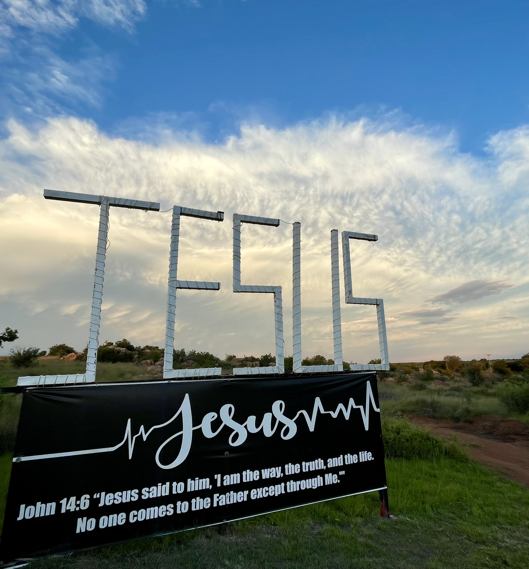 JESUS sign at golden hour with cirrus clouds