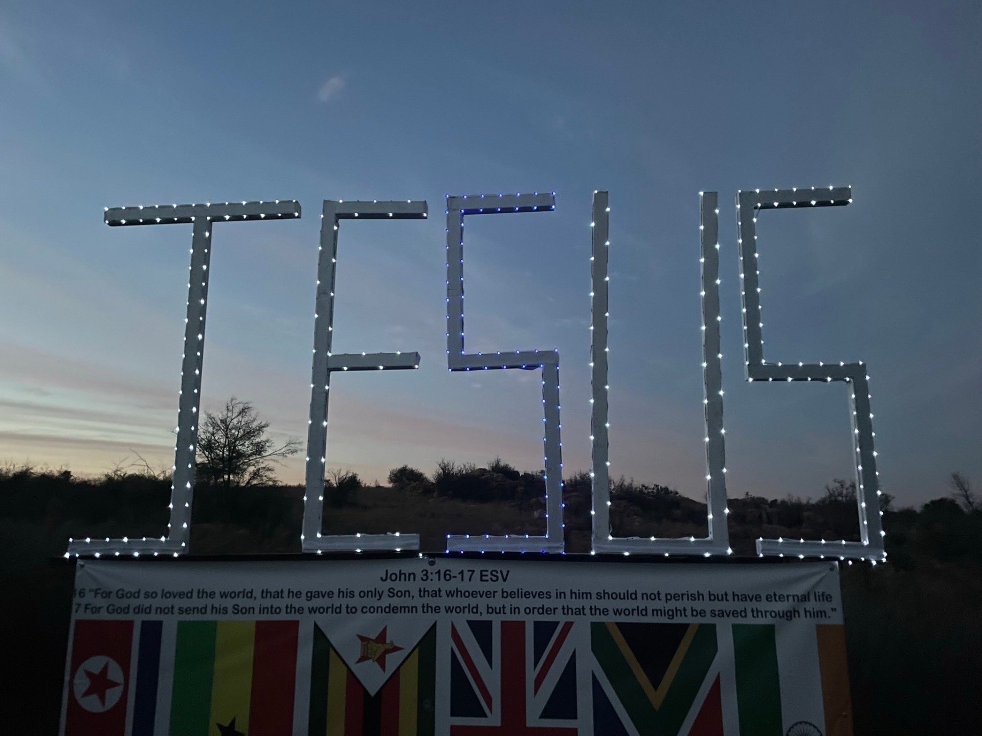 JESUS sign illuminated with lights at twilight