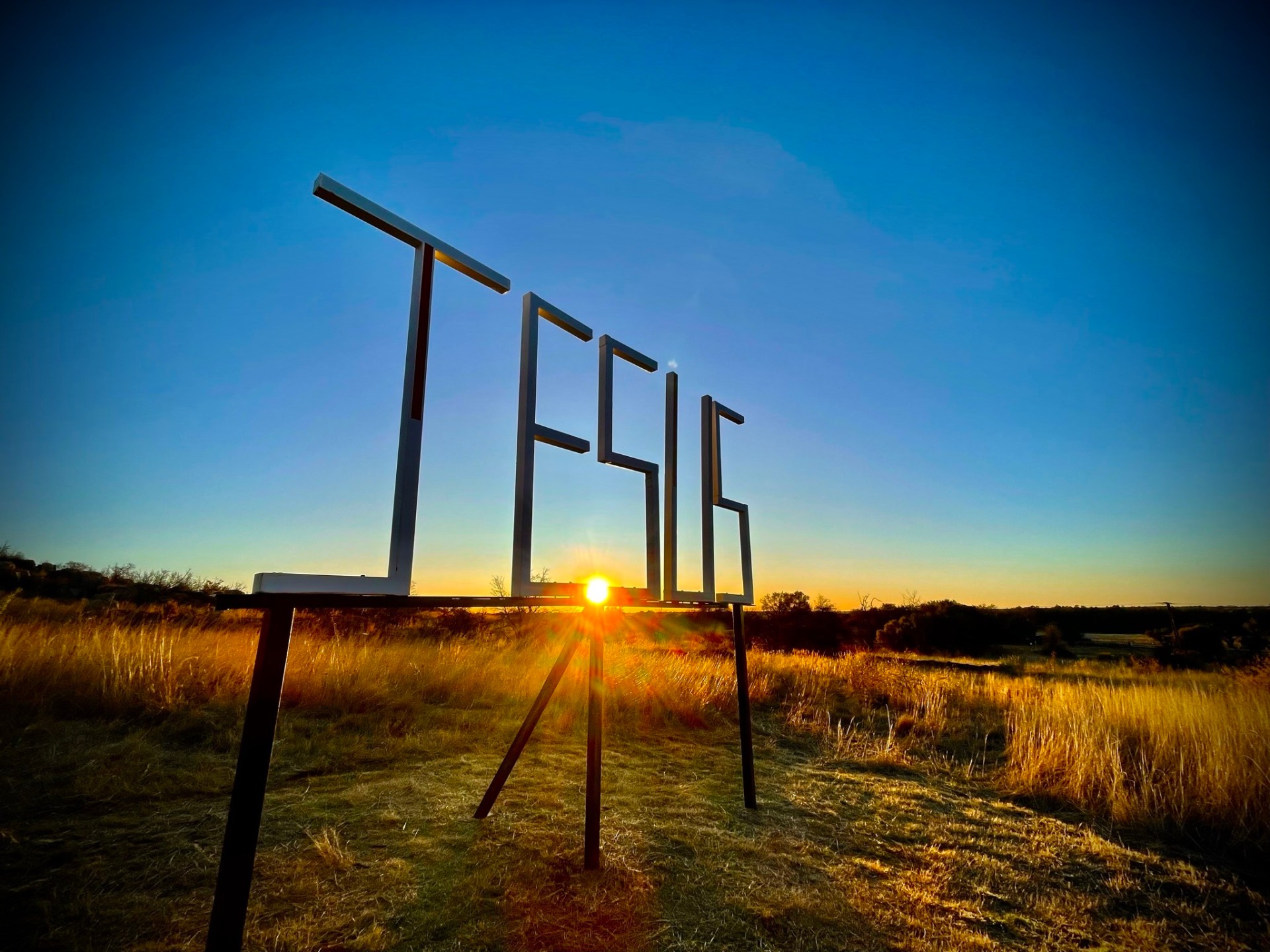 JESUS sign silhouetted against a brilliant golden sunset