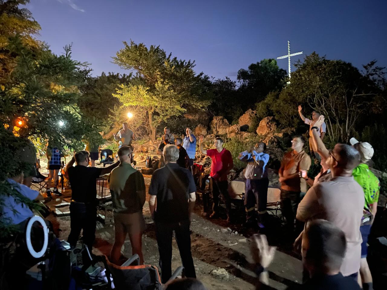 Men gathered around a bonfire at night