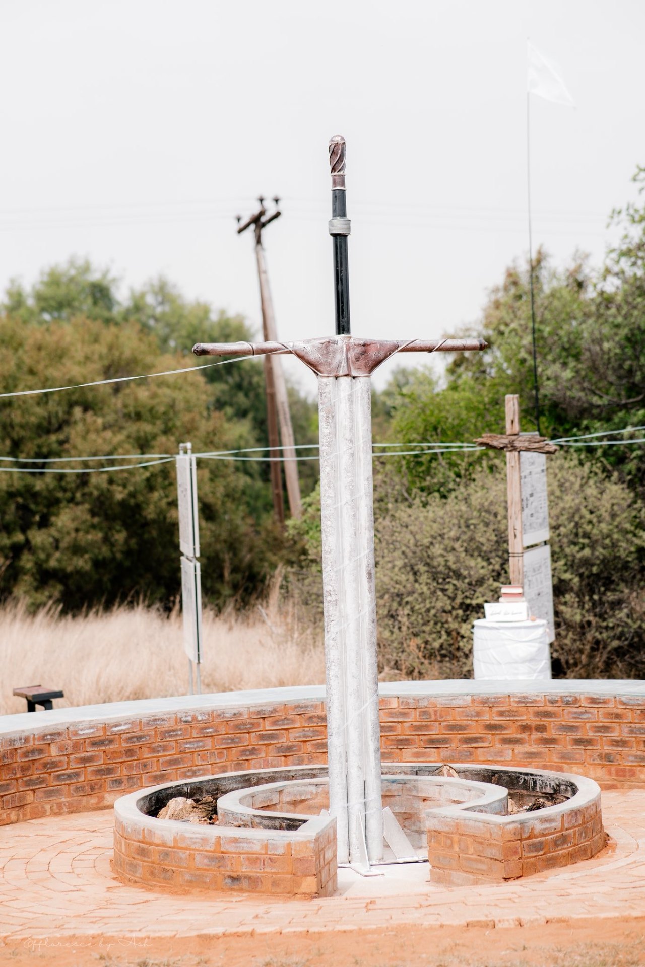 Sword sculpture standing tall above a brick fire pit