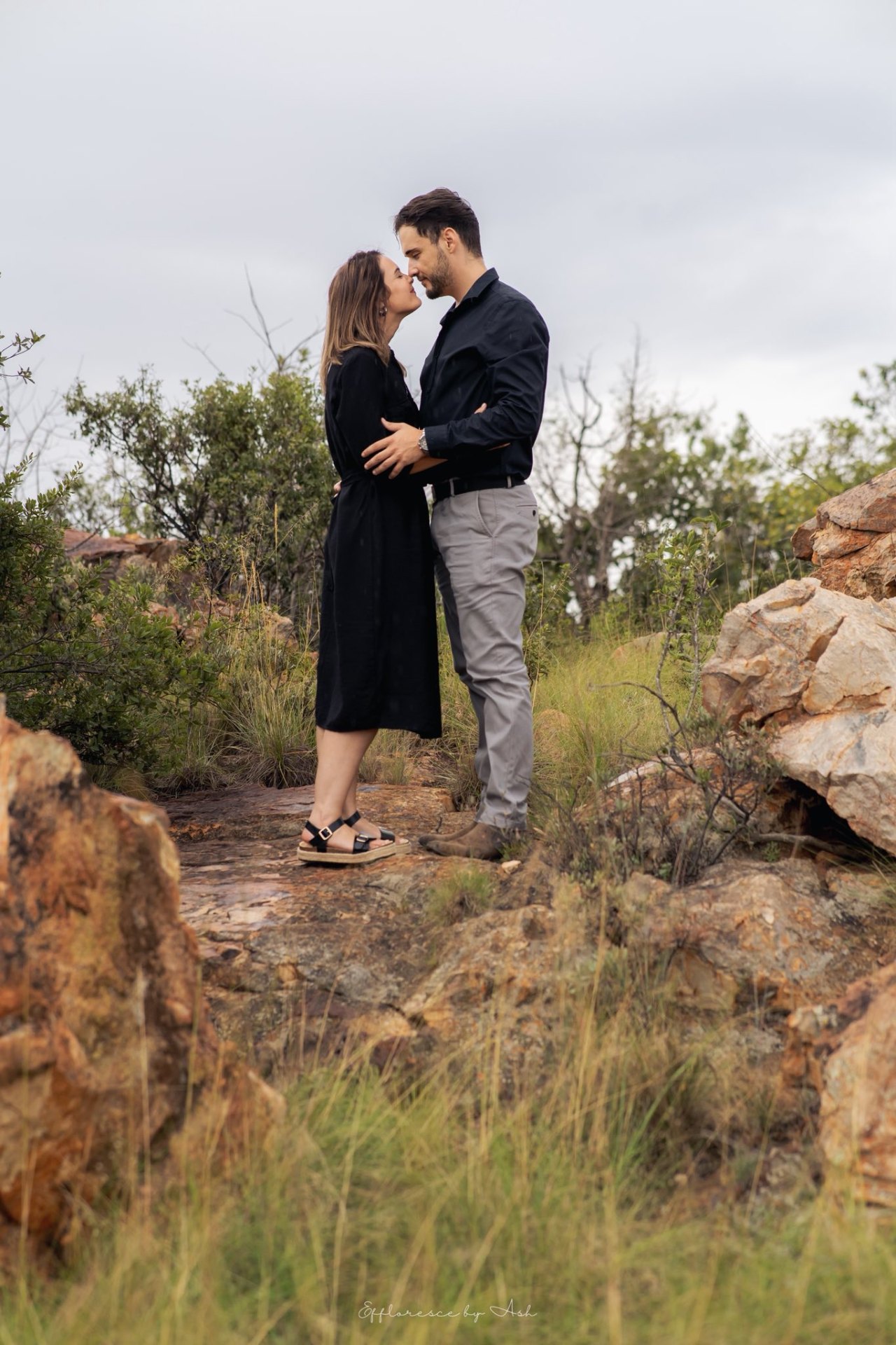 Couple sharing a tender moment on the rocky hillside